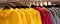 Bright colorful autumn raincoats hanging at a fashion store. Closeup of multi-colored yellow, red, grey, waterproof