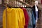 Bright colorful autumn raincoats hanging at a fashion store. Closeup of multi-colored yellow, red, grey, waterproof