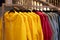 Bright colorful autumn raincoats hanging at a fashion store. Closeup of multi-colored yellow, red, grey, waterproof