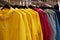 Bright colorful autumn raincoats hanging at a fashion store. Closeup of multi-colored yellow, red, grey, waterproof