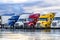 Bright colorful big rigs semi trucks with semi trailers standing in the row on truck stop parking lot at early morning