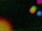 Bright colorful orbs are isolated by a black background with green granules