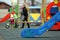 Bright colorful slides on nursery playground with soft rubber flooring on bright sunny summer day. Children activities and