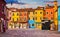 Bright coloured houses on Burano island Venice Italy with blue sky and clouds.