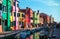 Bright coloured houses on coast of channel in Burano island
