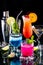 Bright colourful glowing cocktails, against a black background.