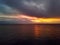 Bright colourful sunset with gloomy cloudy sky over Mediterranean Sea calm smooth waters