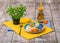A bright composition of an ice-cream plate, orange bottle, and a green Chinese plant. A cute dinner set on a wooden