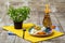 A bright composition of a round plate, orange bottle, and a green Chinese tree. A cute dinner set on a wooden background