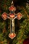 Bright crucifix hanging on green pine tree