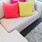 Bright cushions on gray corner sofa