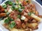 Bright delicious Canadian poutine with green onions 2019