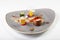 Bright dish of vegetables and mushrooms on gray plate on white b