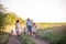 Bright diversity family walks on the paths in field with Samoyed dog. Traveling with pets