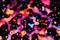 Bright drops of paint pink, orange, blue on a black background. Abstraction. Art image