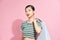 Bright emotional portrait of a beautiful young woman posing with shopping bags, isolated on pink background