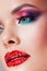 Bright eye makeup and red lips in rhinestones. Pink and blue color, colored eyeshadow.