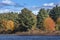 Bright fall foliage along shoreline of lake, Mansfield Hollow, C