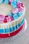 Bright festive cake with multi-colored meringues on a table on a light background, holiday gender of the unborn child