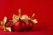Bright festive New Year background - red glossy balls with gold ribbons on deep silky red backdrop, closeup, copy space. Christmas