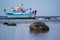 Bright fishing boat in the roadstead in the morning at low tide