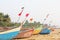 Bright fishing boats stand on the sand in India, GOA. Multicolored Indian boat on the background of the sea. A crow or a bird sits