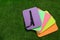 Bright foam tourist seat mats on green grass, flat lay. Space for text