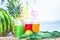 Bright Fresh healthy juices, fruit, pineapple, watermelon on the background of the sea. Summer, rest, healthy lifestyle Copy space