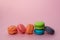 Bright fresh multi colored macaroons for the birthday table with on a pink background. Celebrative composition