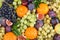 Bright fruit background, top view. Grape, figs, orange tangerine and plum with green leaves