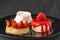 Bright fruit cakes on black plate. Fruit desserts with fresh strawberries. Appetizing pastry sweets
