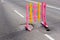 Bright funny pink-yellow wooden barrier on the road