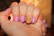 Bright gel polish on fuchsia nails with a charming sun pattern is a funny smile