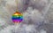 Bright glass rainbow colored Christmas ball, bauble hanging on a white artificial christmas tree. The concept of the holiday,