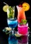 Bright glowing cocktails reflecting on glass, against a black background