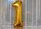 Bright gold balloon number one 1 flies background white translucent curtain