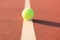 Bright greenish yellow tennis ball on the line