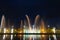 Bright high jets of singing and dancing fountains in the night sky on the embankment of the city of Batumi.