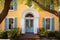 bright-hued colonial revival house with a door having an arched fanlight over it