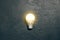 Bright idea glowing light bulb a dark grunge background. Creative inspiration, planning ideas concept