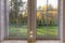 Bright interior of the room in wooden house with a large window overlooking the autumn courtyard.