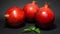 Bright juicy pomegranate fruit, black background, in the photo three fruits are located nearby