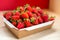 Bright juicy selected strawberries in a portioned cardboard box.