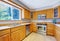 Bright kitchen room interior with tile floor and light brown storage cabinets.