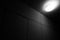 Bright lamp on the ceiling in dark room black and white minimalistic image
