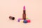 Bright lipstick on a colorful stand on a beige background