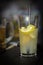 Bright lucent yellow drink lemonade with lemon slices and in darkness