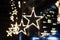 Bright luminous stars of garland on a dark background and beautiful bokeh. New Year`s festive interior decoration