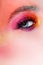 Bright makeup and face art, close-up of the eye. Bright pink eye shadow and glitter.
