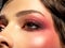 Bright makeup on a woman`s eye. Bright red eye makeup. Macro shot of a woman`s eye with cherry-colored blush. Colorful and vivid